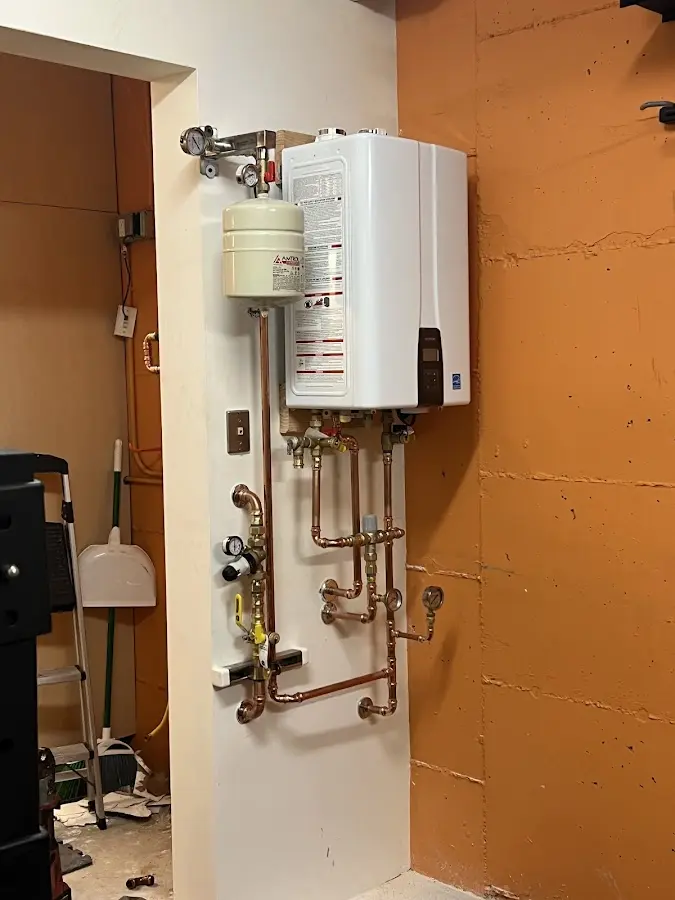 Plumbing technician inspecting water heater connections in Gurnee
